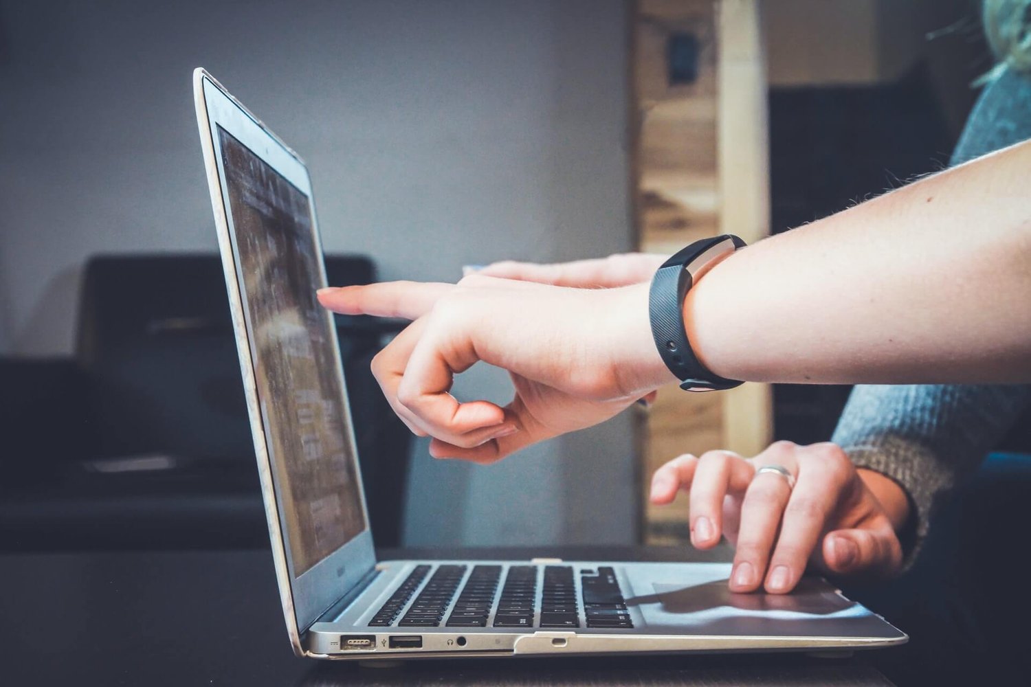 Hands pointing to computer
