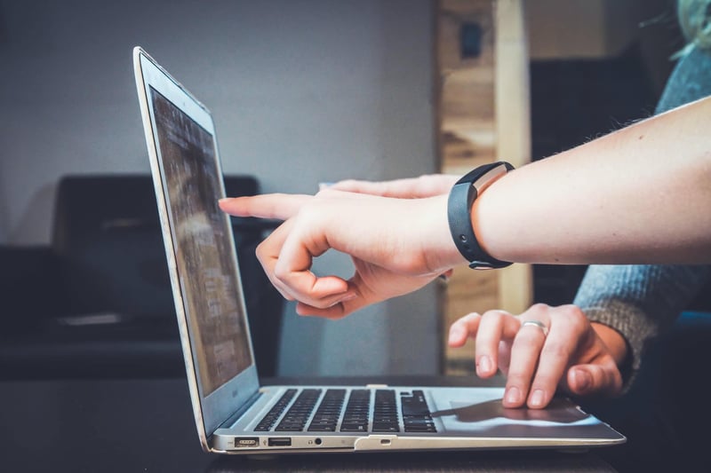 Hands pointing to computer